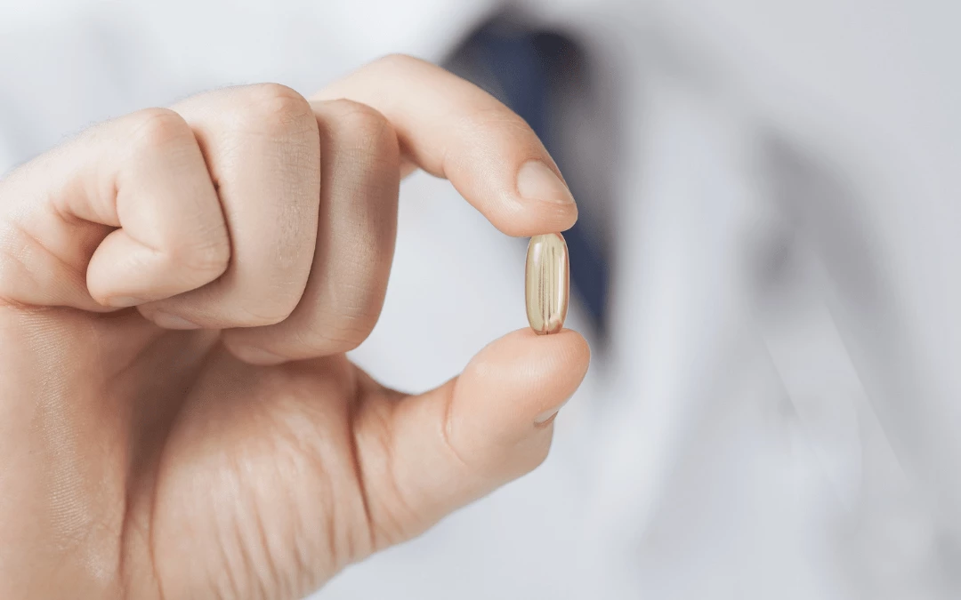 Doctor In Background Holding A Fish Oil Capsule Upclose