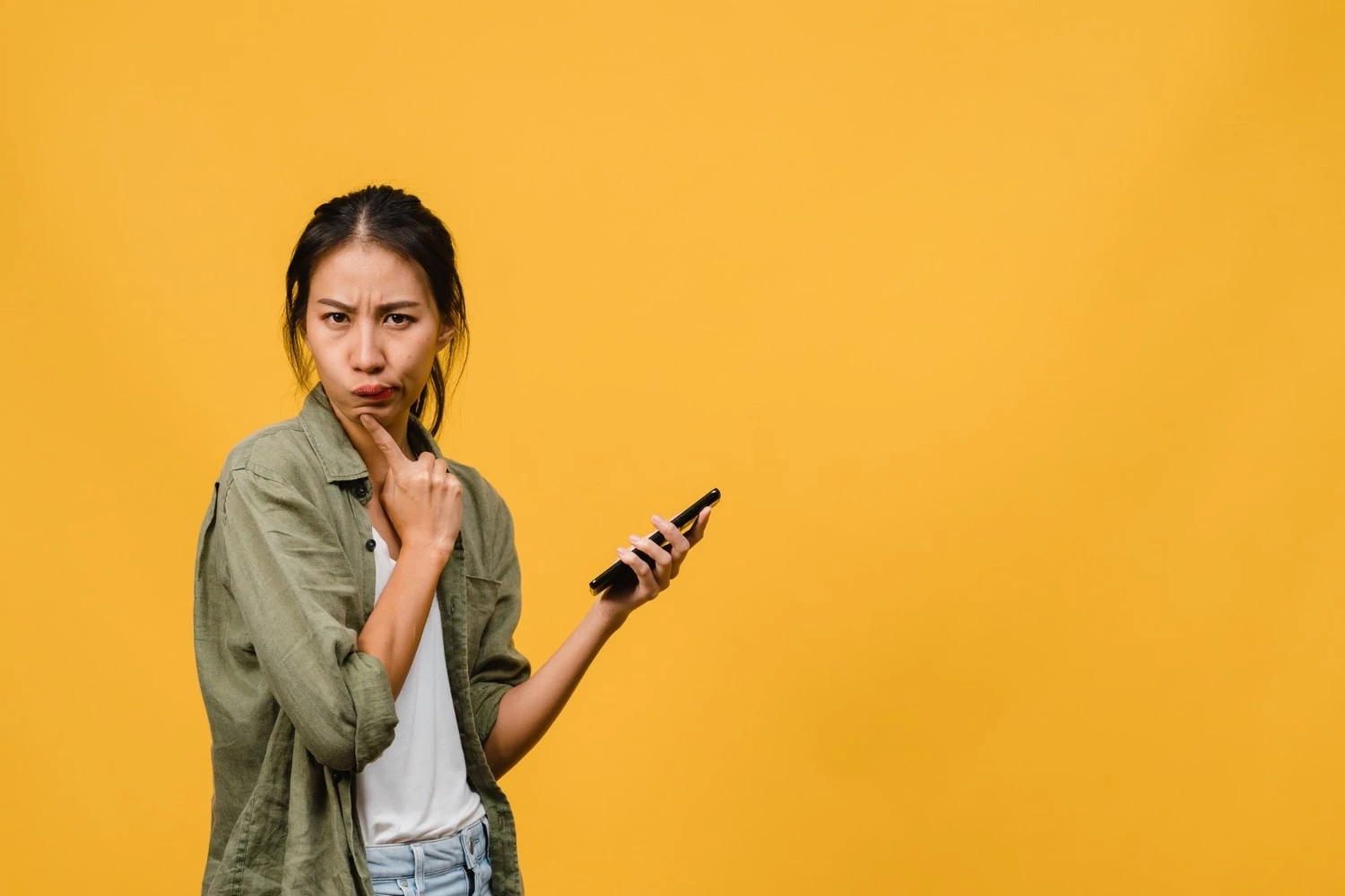  Young Asia Lady Using Phone With Positive Expression Dressed Casual Cloth Yellow Wall