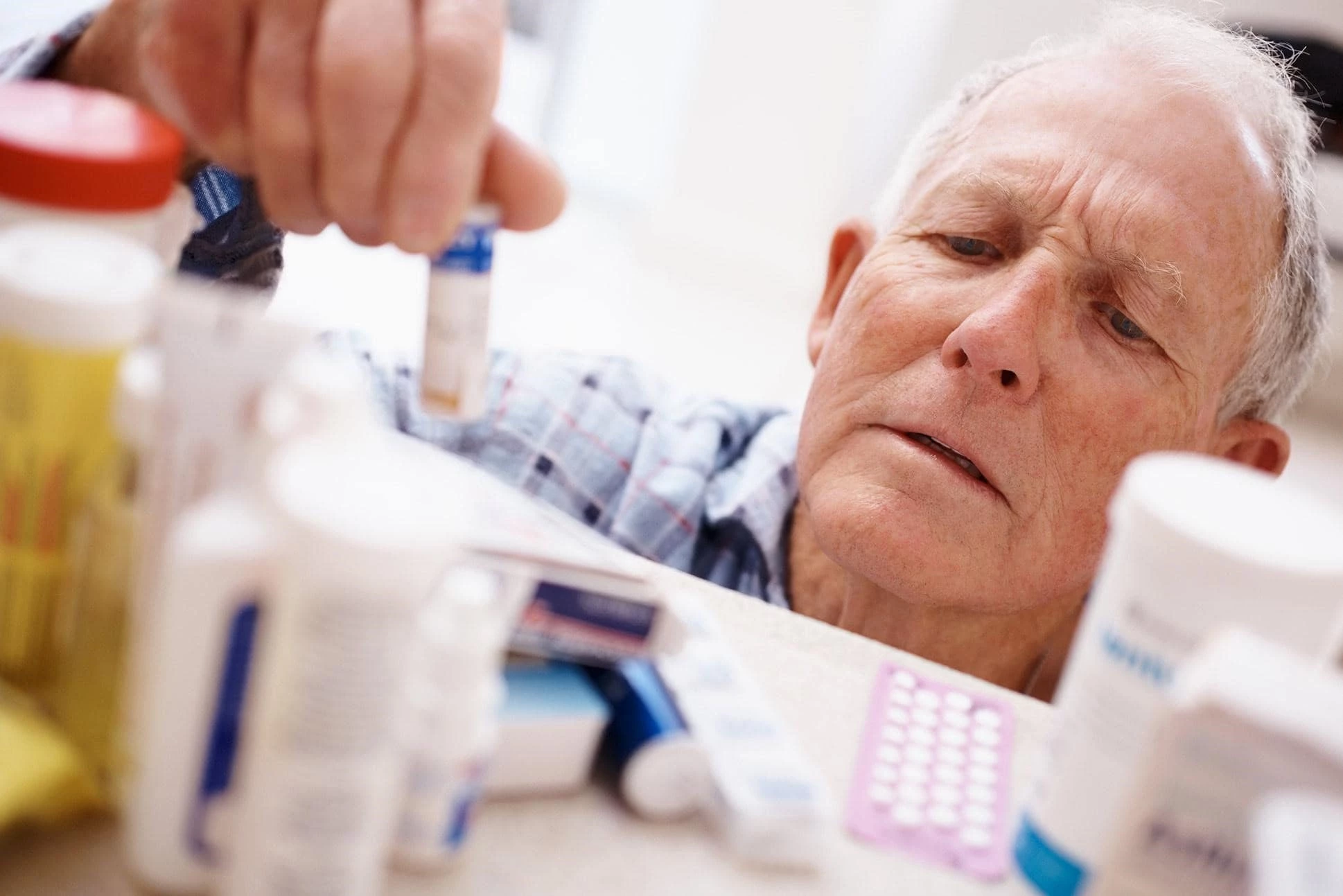 senior-holding-and-looking-at-medicines-upclose