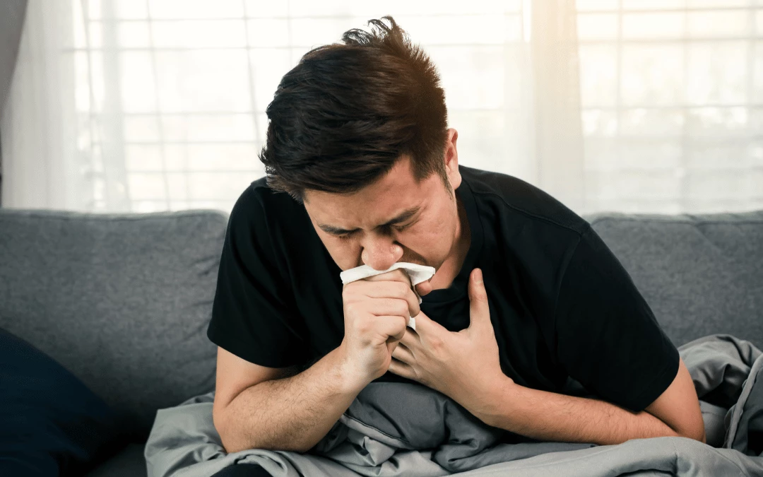 asian-man-coughing-with-hand-on-chest-and-another-hand-covering-mouth-with-tissue